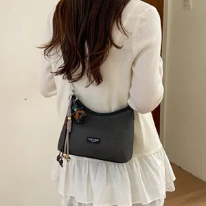 Vintage hobo shoulder bag for women, casual autumn crossbody bag with stylish charms and strap.