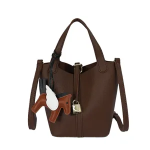 Brown leather bucket bag with cute horse charm, chic shoulder crossbody handbag for women daily.