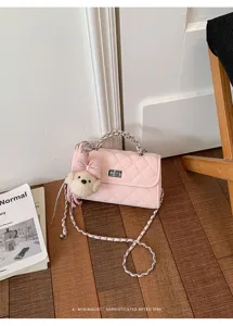 Pink quilted shoulder bag detail showcasing the chic metal chain and cute bow bear charm.