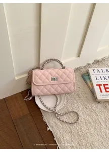 Chic pink quilted chain shoulder bag featuring elegant metal lock and stylish retro aesthetic.