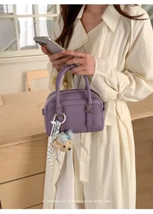 Sac a main Boston en cuir violet, style chic et elegant avec un joli pendentif ourson.