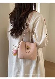 Borsa a secchiello in pelle rosa con chiusura in metallo, elegante borsa a tracolla da donna.