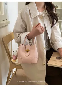 Borsa a secchiello rosa in pelle minimalista con chiusura in metallo e ciondolo chic.
