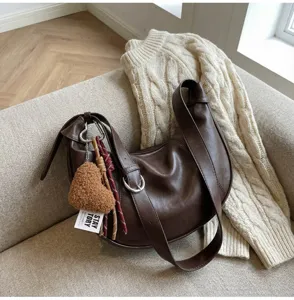 Detailed view of vintage dark brown hobo shoulder bag with stylish charm and soft slouchy design.