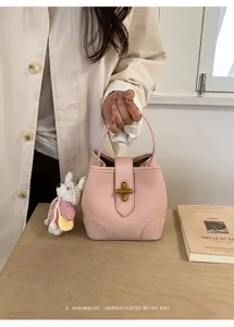 Elegante borsa a secchiello in pelle rosa con chiusura in metallo e ciondolo per donne.