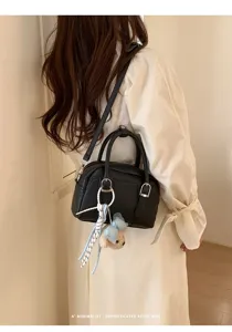 Sac à main Boston noir minimaliste chic pour femme, sac bandoulière polyvalent avec pendentif.