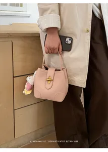 Borsa a secchiello in pelle rosa con chiusura in metallo e manico, elegante borsa minimalista.