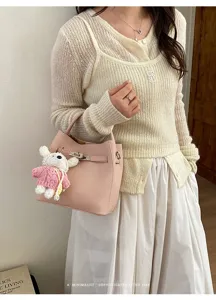 Korean style pink litchi grain leather bucket bag with cute rabbit charm and metal lock.