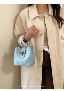 Borsa a secchiello in pelle celeste chic con chiusura metallica, design retrò per uso quotidiano.
