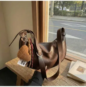 Retro brown hobo shoulder bag detail, highlighting soft PU leather and curved modern aesthetic.