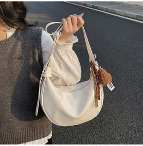 Minimalist white hobo shoulder bag for women, stylish casual crossbody crescent bag with charm.