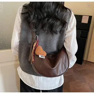 Retro brown leather croissant hobo shoulder bag with cute heart pendant and scarf charm.
