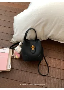 Elegante borsa a secchiello in pelle nera con manico e chiusura metallica per donna.
