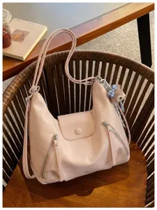 Borsa a tracolla rosa morbida da donna con tasche multiple e ciondolo in peluche.