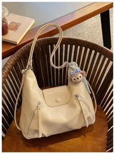 Borsa a tracolla hobo beige con dettaglio ciondolo in peluche, elegante shopper.