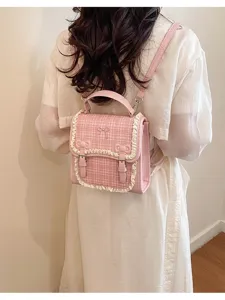 Detailed back view shot of a cute pink plaid mini backpack featuring sweet lace trim and bows.
