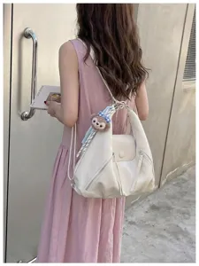 Zaino e borsa a tracolla multifunzionale bianca elegante con ciondolo a forma di orsetto.