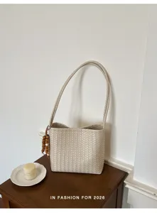 Vue détail sac seau en cuir tissé beige avec charme de perles en bois pour femme chic