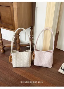Vue détaillée du sac seau tressé pour femmes en cuir souple avec charmante pampille de perles.