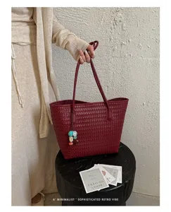 Vista dettagliata della borsa tote intrecciata da donna in rosso bordeaux con elegante.