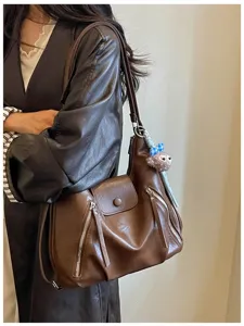 Borsa a tracolla vintage in pelle marrone con ampio spazio e grazioso ciondolo in peluche.