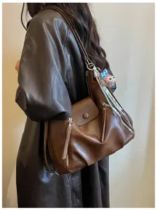 Borsa a tracolla multifunzionale in pelle marrone, zaino elegante con ciondolo chic.