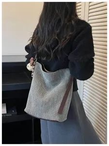 Grande borsa a secchiello a spalla intrecciata con design in rete e dettagli in pelle marrone.