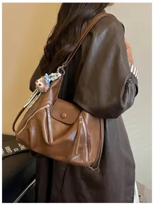 Primo piano dettagliato dello zaino multifunzione in morbida pelle PU marrone con tasche con zip.