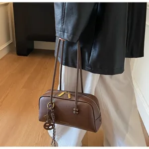 Classic brown faux leather bowling bag with top handles, chic vintage design for women.