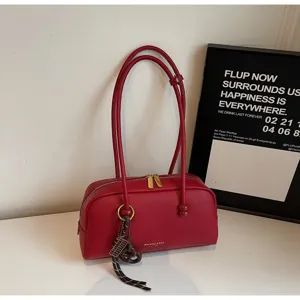 Red leather bowling shoulder bag, minimalist retro design with double straps and zipper.