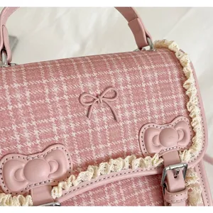 Pink plaid handbag detail, sweet bow and lace trim design, fashion shoulder bag close-up.
