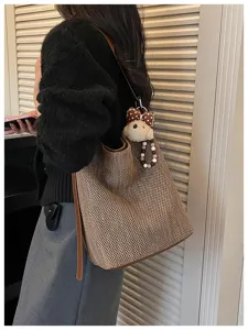 Grande borsa a tracolla intrecciata da donna, elegante borsa a secchiello marrone con orsetto.