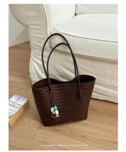 Borsa tote in pelle intrecciata marrone vista dettaglio con doppi manici e ciondolo di perline.