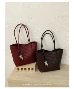 Vista dettagliata della borsa tote retrò in pelle intrecciata con ciondoli in pietra.