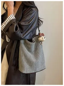 Dettaglio borsa a secchiello intrecciata, stile casual a tracolla con grazioso ciondolo.