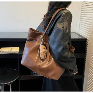 Brown PU leather shoulder tote bag, stylish retro casual commuter bag with cute bear pendant.