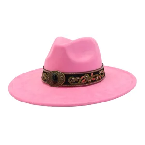 Detalle de sombrero fedora de ante rosa con banda decorativa de patrón étnico y hebilla de piedra negra.