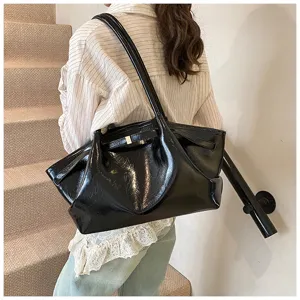Detailed view of the stylish black glossy tote bag, showing its unique pleated design.