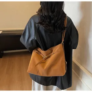 Detailed view of the stylish brown leather convertible backpack and shoulder bag with metal buckles.