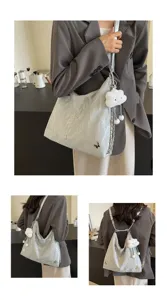 Detail view of silver crumpled tote bag showing butterfly charms and plush cloud design.