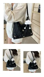 Detailed view of black crumpled shoulder bag with metal butterflies and cute cloud charm.