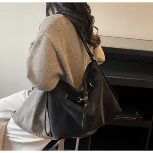 Black commuter slouchy shoulder bag detail, versatile dual-use design with metal hardware.