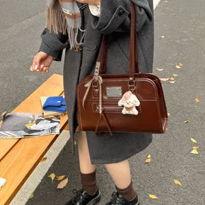 Vintage oil wax leather handbag for women, chic boston shoulder bag with cute plush charm.