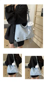 Detailed shot of light blue crinkled tote bag with cute butterfly accents and fluffy cloud charm.