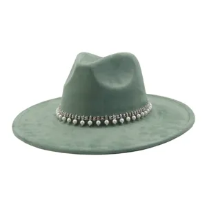 Close-up detail of the green suede fedora hat showcasing rhinestone and pearl tassel band.