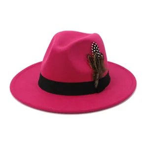 Close-up detail view of the hot pink fedora hat featuring a black band and feathers.