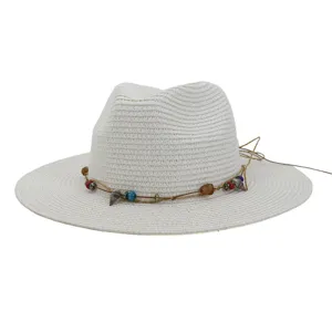 Detail opname van witte strohoed met schelp- en kralenband voor de strandvakantie.