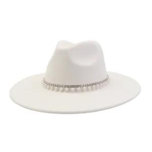 Detailed view of white fedora hat featuring sparkling rhinestone and elegant pearl trim band.