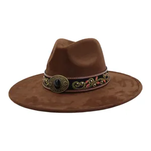 Primer plano del sombrero fedora de antelina marrón con banda étnica vintage y hebilla decorativa.