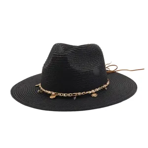 Schwarzes Strohhut Detail mit Kette, Perlen und Anhängern für den perfekten Sommerstrand.